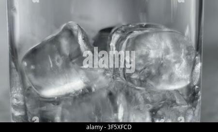 Ice cubes inside a glass with water, close-up, illustrating refreshment, coldness, and transparency Stock Photo