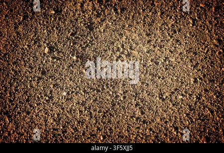 Brown earth and gravel macro texture background high contrasted with vignetting effect Stock Photo