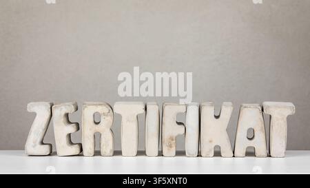 Certification Idea From German Word ZERTIFIKAT Shown With Minimal Concrete Typography On Background Stock Photo