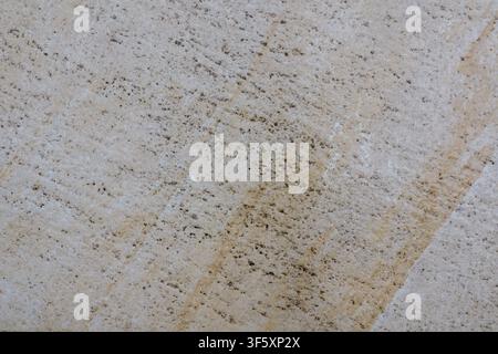 Light tile with pronounced rough texture, dark speckles and a naturally uneven stone surface pattern Stock Photo
