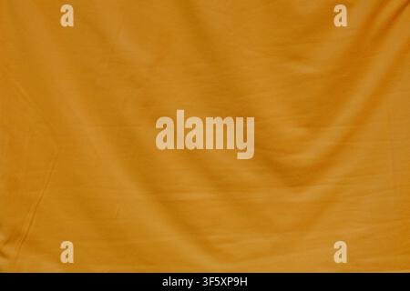Bright orange fabric close up with soft textile texture, natural folds and small irregularities across the surface Stock Photo