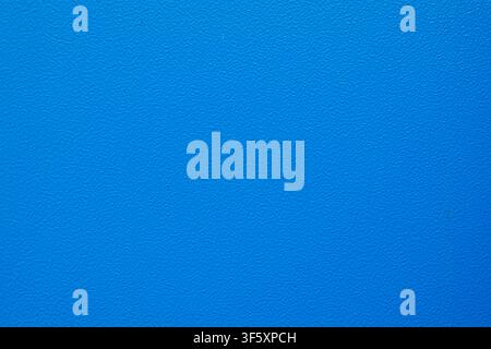 Bright blue uniform surface with a fine grain texture and consistent saturated color across the entire frame Stock Photo