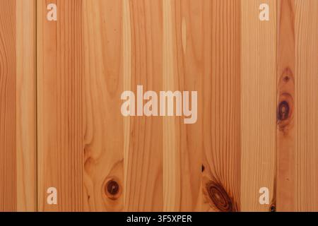 Surface of natural wooden boards in warm tones with vertical grain, dark knots and an expressive natural wood pattern Stock Photo