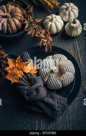Cozy autumn table setting with knitted pumpkins and fall leaves Stock Photo