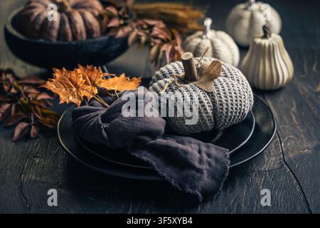 Cozy autumn table setting with knitted pumpkins and fall leaves Stock Photo