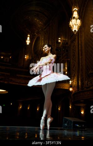 Ballerina Crossing Arms in Poised Stance on Theater Stage Stock Photo