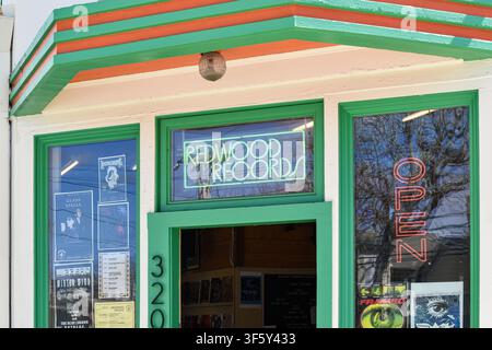 Exterior entrance of Redwood Records independent record store in Santa Cruz, California, USA, displaying colourful storefront, neon sign and vinyl rec Stock Photo