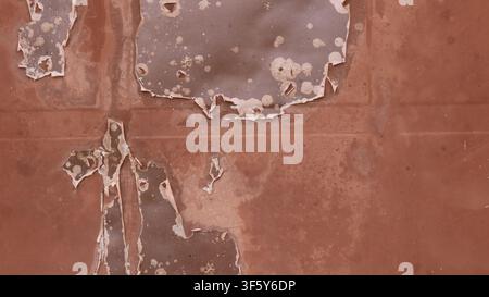 old, rusty, brown metal surface. The metal shows areas of heavily peeling and flaking paint, dark spots of corrosion, small cracks, plaque, and traces Stock Photo