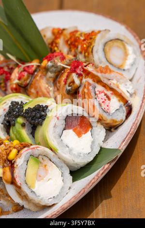 Assorted premium sushi roll platter featuring avocado, tuna, salmon, black caviar, shrimp, and various toppings. A gourmet Japanese seafood feast serv Stock Photo