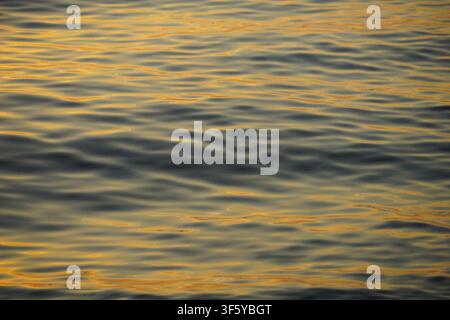 Sea surface with sparkling yellow reflection of the sun rays on the surface of the sea water Stock Photo