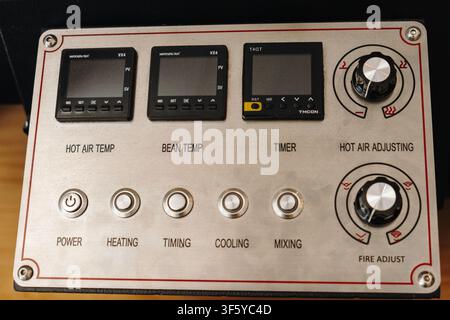 Professional coffee roasting machine control panel with temperature displays, timer and adjustment knobs. Detailed view of roasting equipment used for Stock Photo