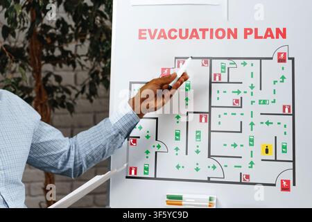 Emergency evacuation plan displayed on a board with marked pathways and exits Stock Photo
