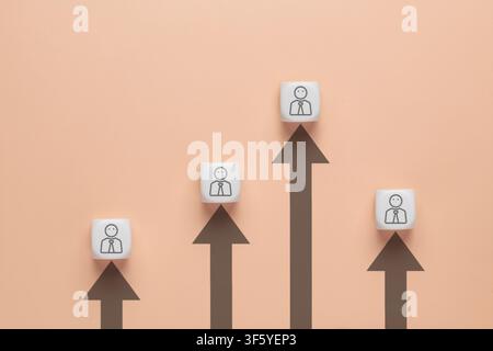 White cubes with businessman icons sitting atop rising dark arrows of varying heights. Career advancement, performance appraisal, corporate hierarchy Stock Photo