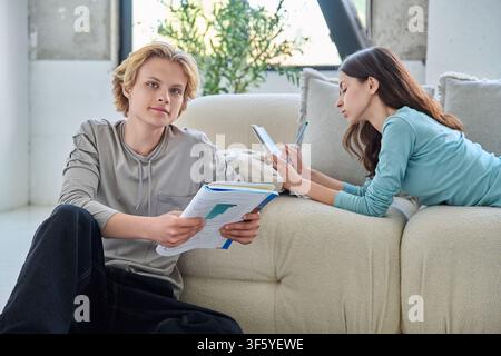 Young students studying and learning together in a modern bright living room Stock Photo