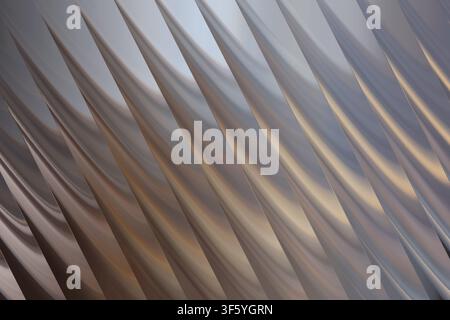 A high-angle view of a modern architectural design featuring repeating, sharp, metallic diagonal fins creating a rhythmic and geometric pattern. Stock Photo