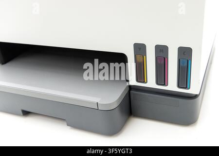 A close up view of a modern color inkjet printer showing the external ink tanks on the front panel Stock Photo