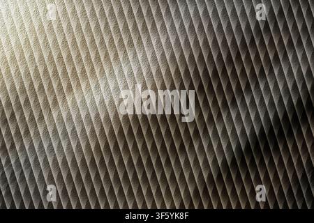 An abstract background with a repeating diagonal line pattern, featuring a sophisticated metallic texture and dramatic lighting highlights. Stock Photo