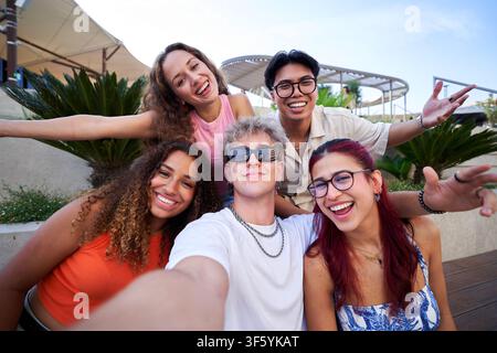 Group of happy young friends taking a selfie outdoors. Stock Photo