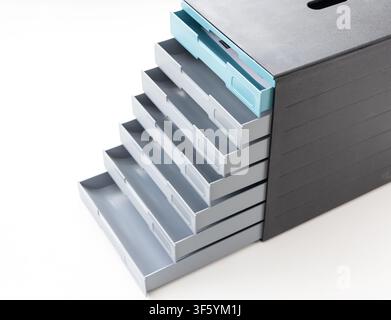 A modern black and gray plastic drawer organizer with multiple open compartments stands against a white background Stock Photo