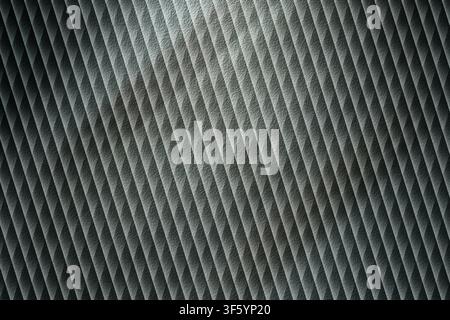 A high-contrast, abstract background featuring a repeating diagonal pattern with a metallic, brushed texture and dramatic lighting effects. Stock Photo