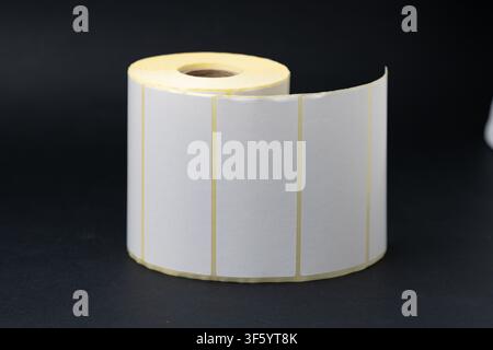 Rolls of blank white adhesive labels isolated on white for direct thermal and thermal transfer printing, packaging, pricing and retail use. Stock Photo