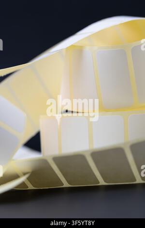Rolls of blank white adhesive labels isolated on white for direct thermal and thermal transfer printing, packaging, pricing and retail use. Stock Photo