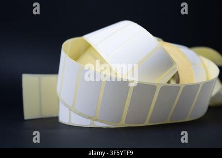 Rolls of blank white adhesive labels isolated on white for direct thermal and thermal transfer printing, packaging, pricing and retail use. Stock Photo