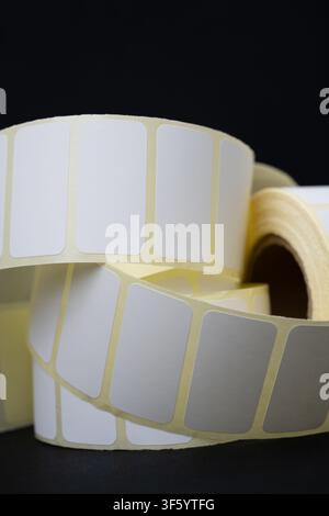 Rolls of blank white adhesive labels isolated on white for direct thermal and thermal transfer printing, packaging, pricing and retail use. Stock Photo