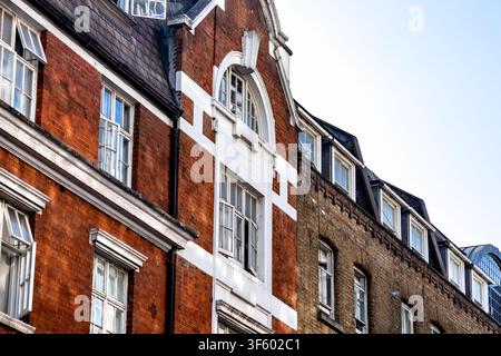 Traditional red brick and Victorian-style residential buildings with white architectural detailing along a street in London, England, United Kingdom Stock Photo