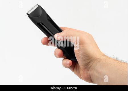 Black hair trimmer tool in hand isolated on white background close up view Stock Photo