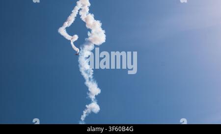 Aerobatic Biplane Trailing a White Smoke Spiral Against a Clear Blue Sky at an Air Show — Precision Flying, Freedom and Adventure Concept Stock Photo