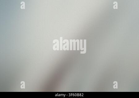 An abstract background image showing a frosted glass surface with a gentle, monochromatic grey gradient and soft light diffusion. Stock Photo
