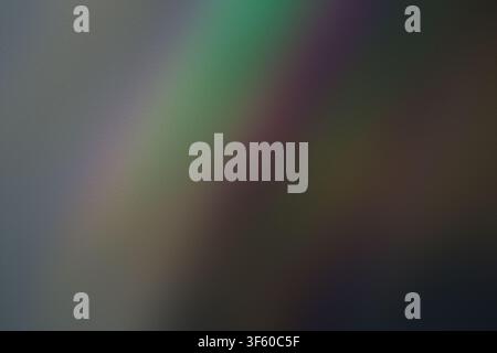 A dark, textured background featuring soft, blurred streaks of green and purple light, creating an ethereal and mysterious atmospheric effect. Stock Photo