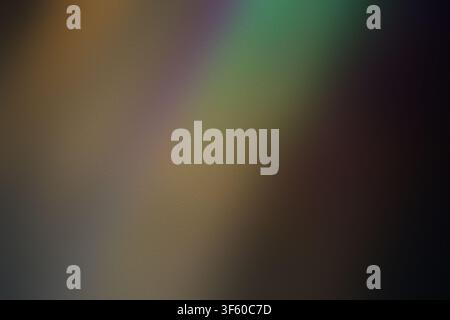 An abstract dark background transitioning through subtle earth tones and hints of green, featuring light leak effects and a fine frosted texture. Stock Photo