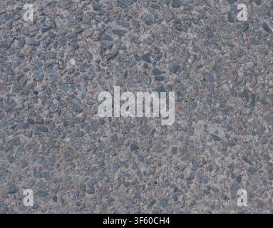 Top view close-up texture of grey rough asphalt, crushed stone aggregate, and coarse concrete pavement. Seamless background pattern for construction, infrastructure, and urban design concepts. Stock Photo