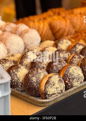 Assorted pastries including chocolate-covered donuts from a bakery with a tempting display. Mobile photo Stock Photo
