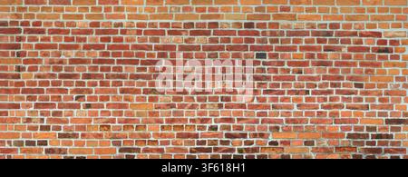 Old red brick wall, partly with some dark bricks Stock Photo