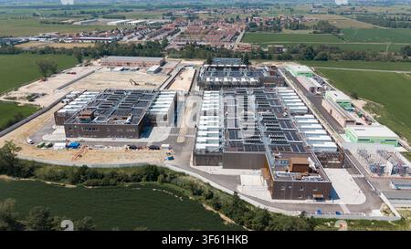 Aerial view of the Stack Infrastructure MIL04 Campus, a large data center facility with multiple buildings and rooftop cooling units, situated in Vell Stock Photo