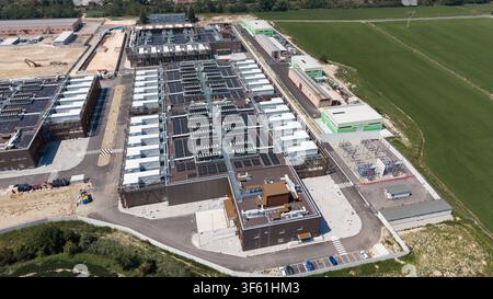 Aerial view of the Stack Infrastructure MIL04 Campus, a large data center facility with multiple buildings, rooftop cooling units, and solar panels, V Stock Photo