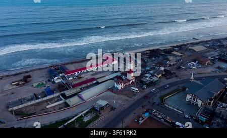 Aerial view of the historic Jamestown Lighthouse surrounded by coastal buildings, roads, and the Atlantic Ocean in Accra, Greater Accra Region, Ghana. Stock Photo