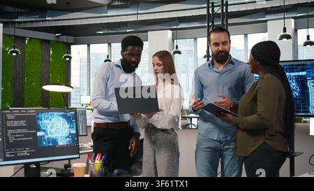 Portrait of teamworking programmers in office developing apps using AI automation. Team of smiling IT experts working on devices, debugging applications with artificial intelligence, camera A Stock Photo