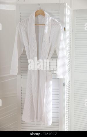 Clean waffle bathrobe hanging on white wall Stock Photo