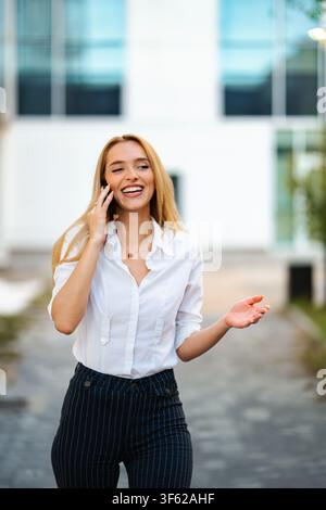 Happy professional woman talking on phone and gesturing Stock Photo
