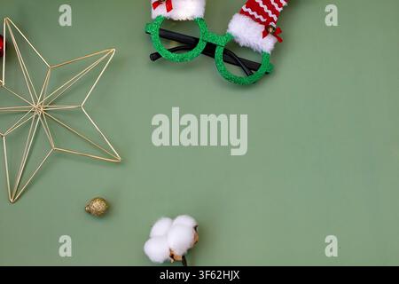 Minimal Christmas Gift Box with Holiday Decorations on Sage Green Background Stock Photo