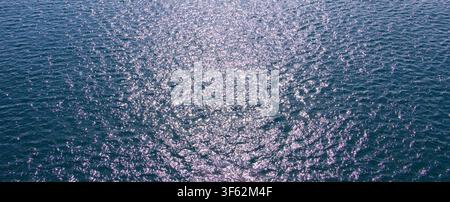 Wide panoramic ocean water surface background with sparkling sunlight reflections on ripples Stock Photo