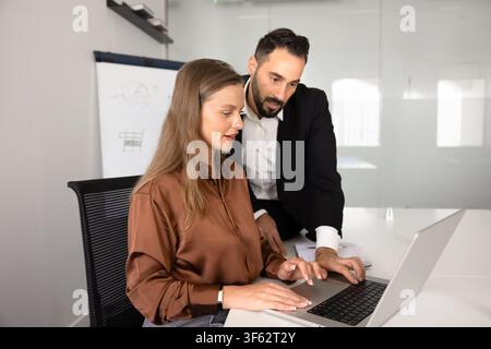 Multiethnic colleagues reviewing project data on laptop Stock Photo