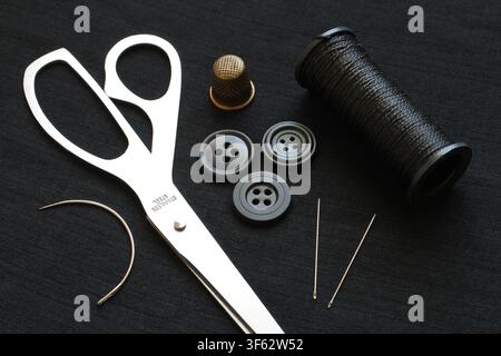 A set of various sewing accessories for sewing and needlework. Accessories for sewing on a dark background. Stock Photo