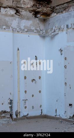 Empty room with partially demolished walls and ceiling during renovation. Interior stripped for remodeling with damaged plaster and construction debri Stock Photo