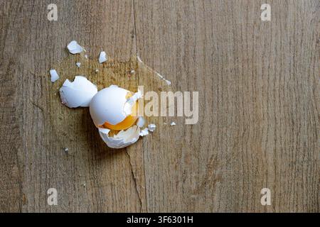 Broken Raw Egg with Cracked White Shell on a Rustic Wooden Table Surface Stock Photo
