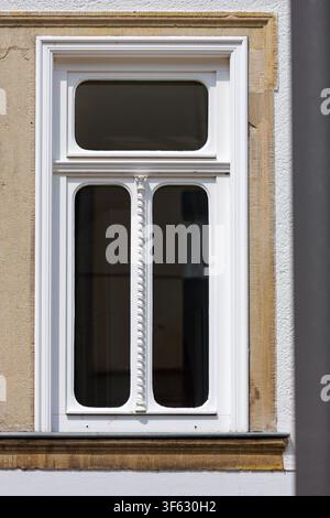 Ornate White Historic Window Framed by Sandstone on a Sunlit Facade Stock Photo